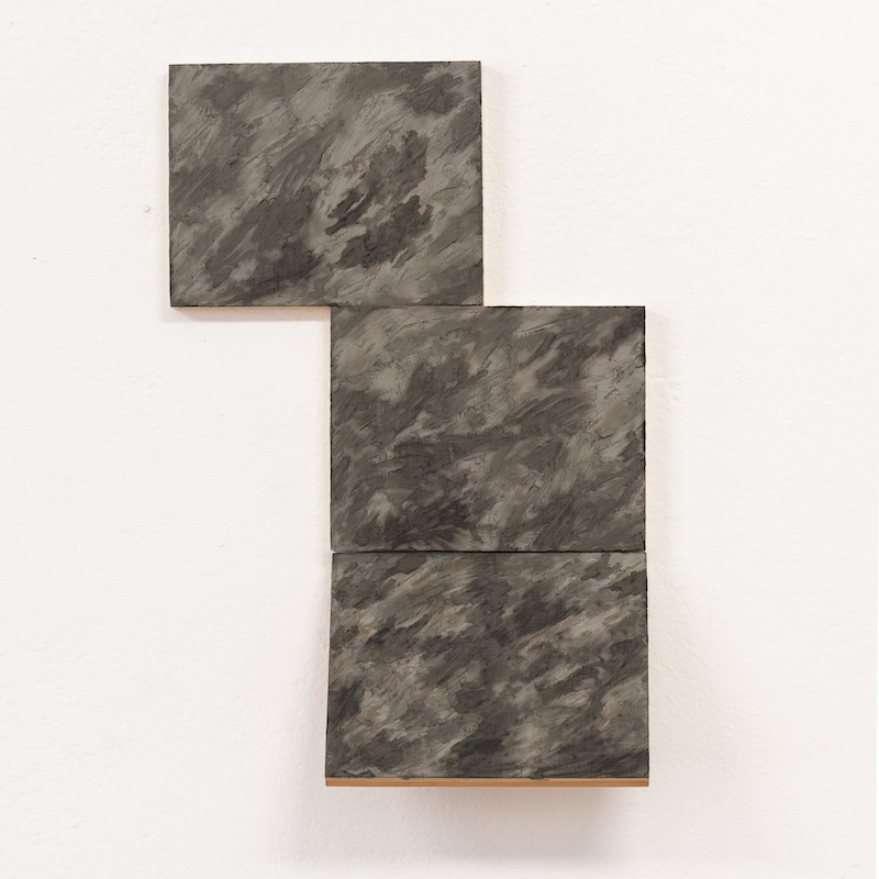 grey scale rectangular paintings on a white wall