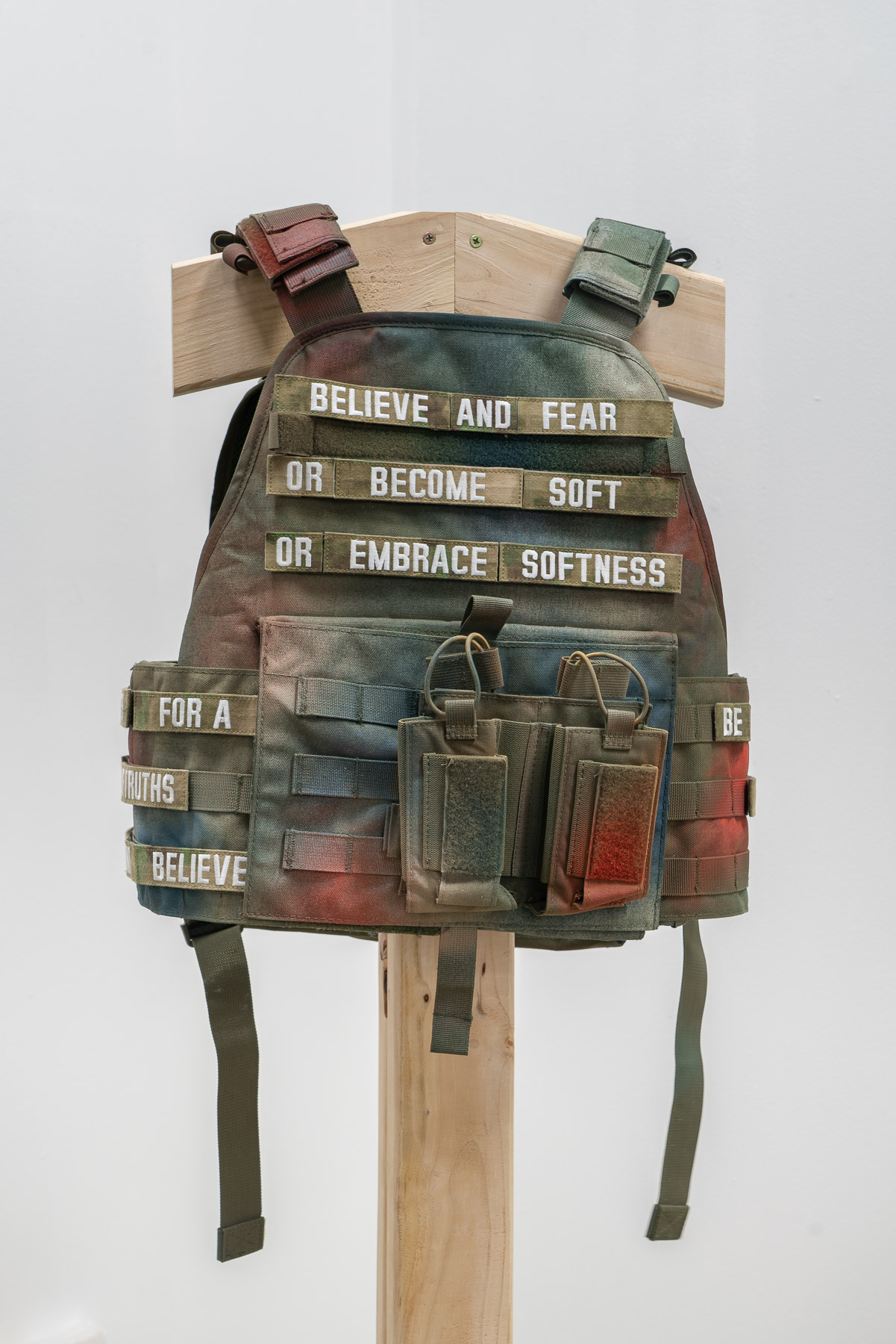 Army Vest with embroidered lettering saying bleive and fear or become soft and embrace softness