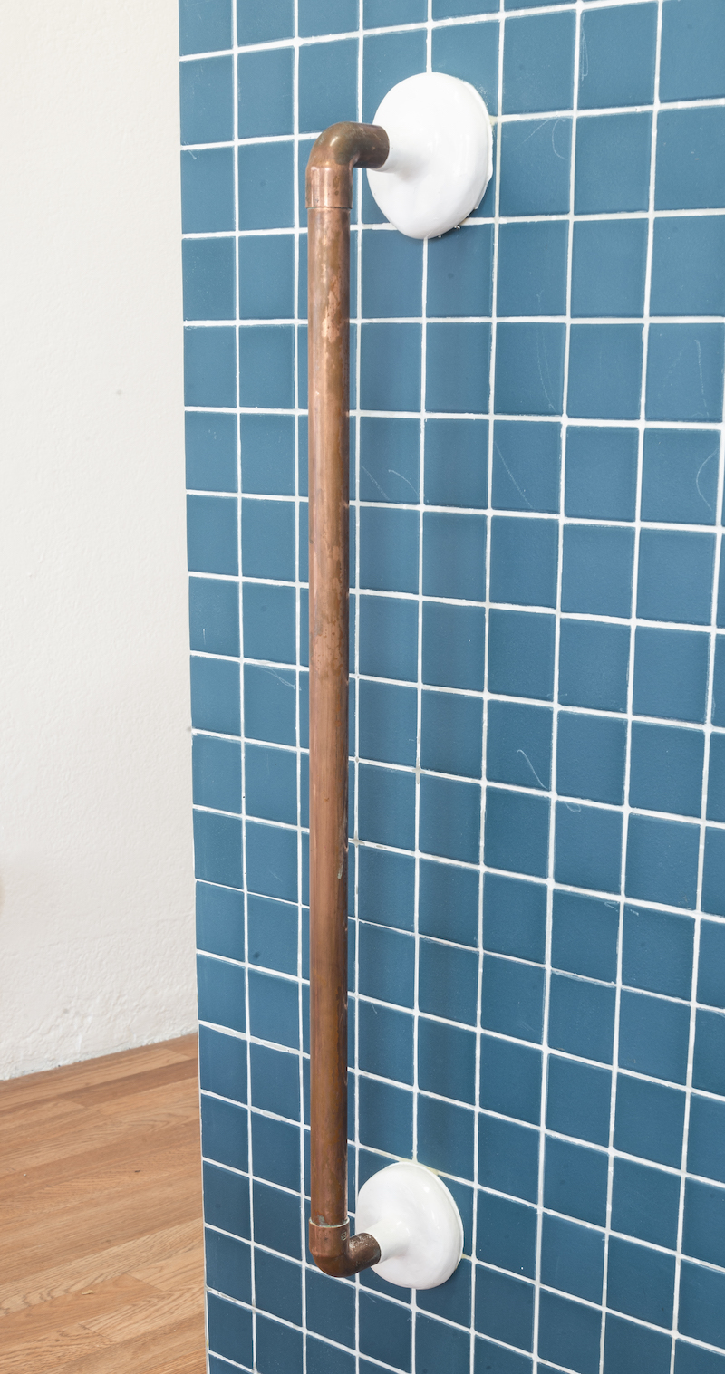 Blue tile corner sock sculpture and pipes