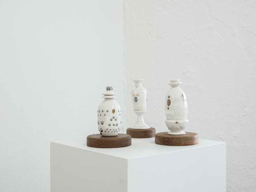 collection of white porcelain perfume bottles on pedestal