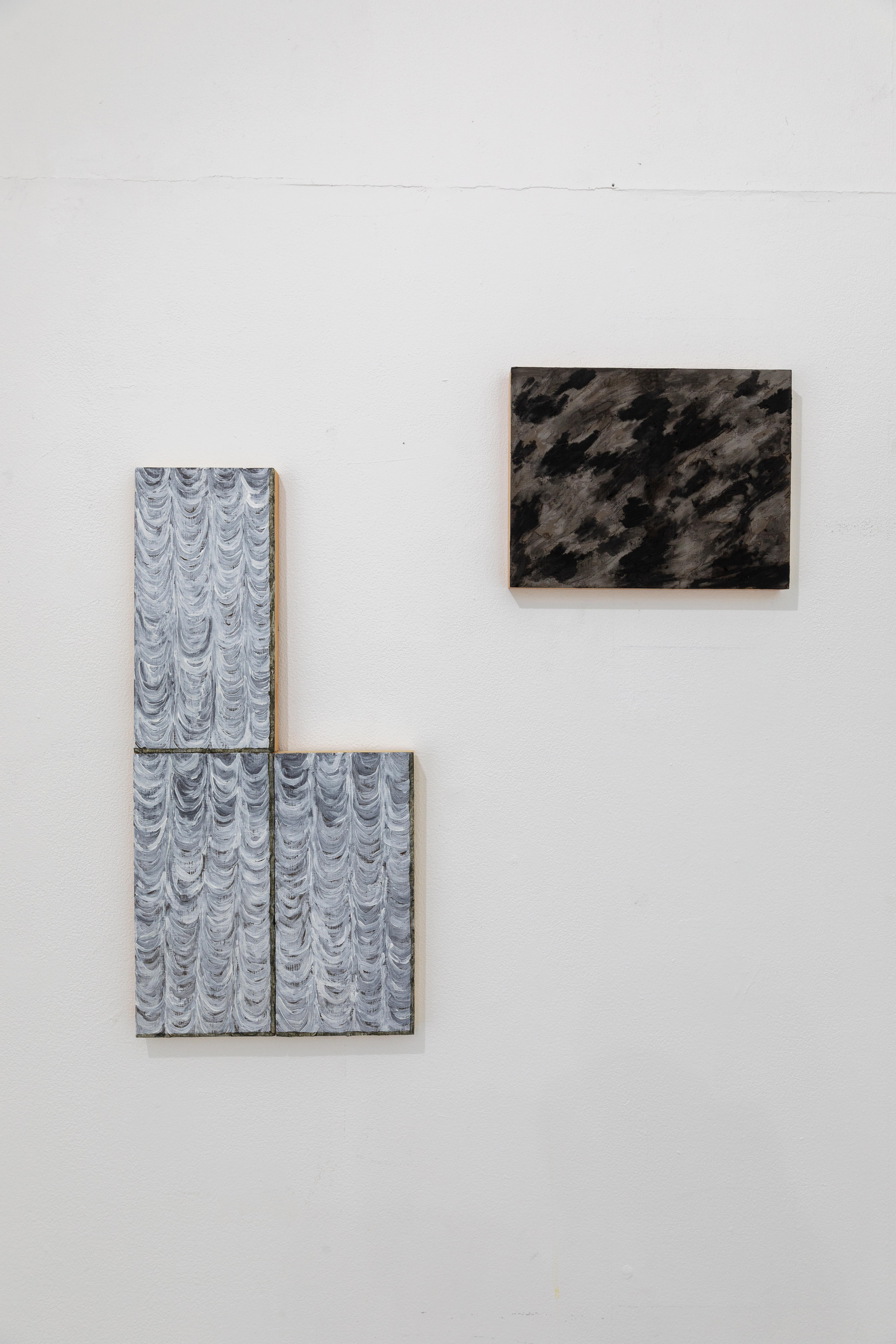 grey scale rectangular paintings on a whitw wall