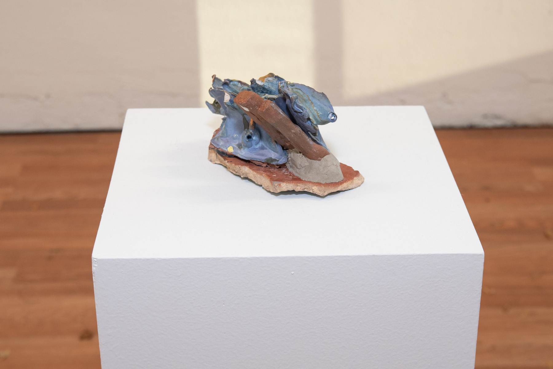 casted form of various objects, glazed with blues & browns